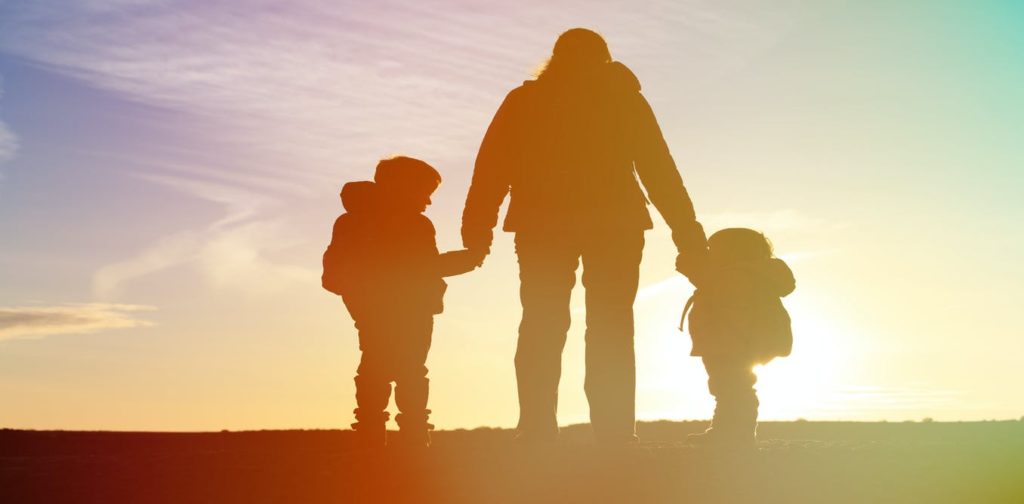 a silhouette of a parent with two small children